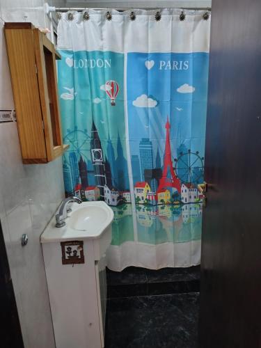 a bathroom with a shower curtain with a sink at El Paraíso in Necochea