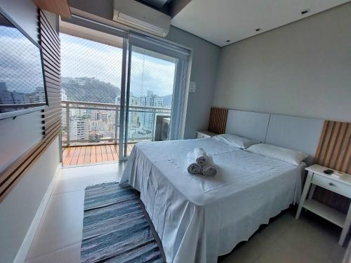 a bedroom with a bed and a large window at Book Santos - Unlimited 2111 Vista Mar in Santos