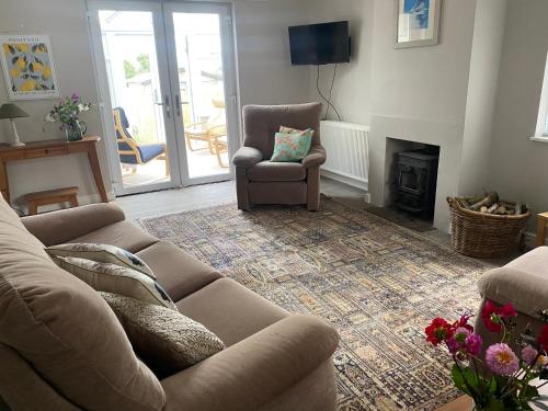 a living room with a couch and a chair and a fireplace at Yealand Redmayne 3 bed Home in Beetham