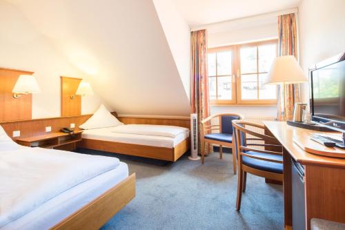 ein Hotelzimmer mit einem Bett und einem Schreibtisch in der Unterkunft Hotel Blume in Freiburg im Breisgau