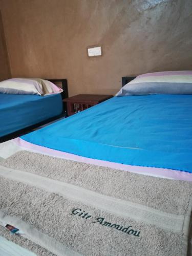 two beds in a room next to each other at Gite Amoudou in Ouarzazate