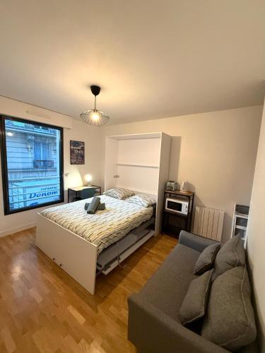 un dormitorio con una cama y un sofá en Studio Boileau Tour Eiffel, en París