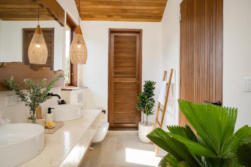 ein Badezimmer mit zwei Waschbecken und zwei Toiletten in der Unterkunft Villa Utopia Uluwatu in Uluwatu
