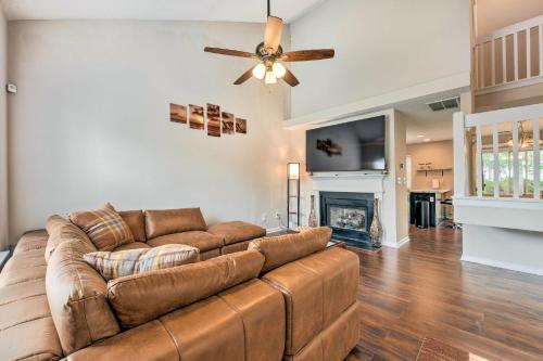 a living room with a brown couch and a fireplace at Chic Charlotte Townhome with Community Pool in Charlotte