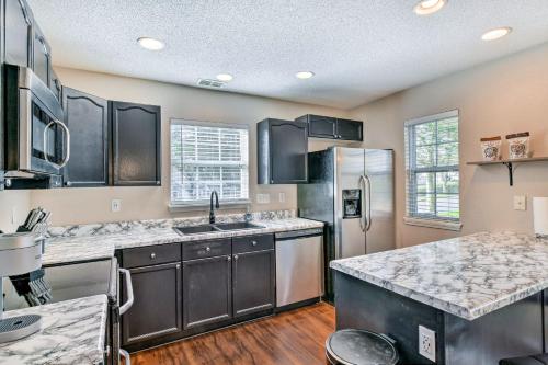 a kitchen with a sink and a refrigerator at Chic Charlotte Townhome with Community Pool in Charlotte