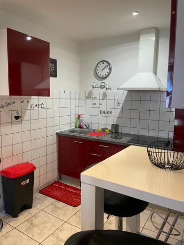 a kitchen with a counter and a clock on the wall at Au cœur de la perle du jura in Champagnole