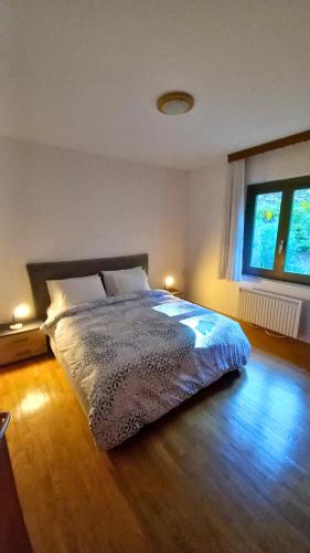 a bedroom with a bed with a wooden floor and a window at Casa Camelia in Intragna