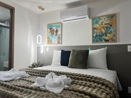 a bedroom with a bed with towels on it at Luxuoso Flat pé na areia no Restinga in João Pessoa