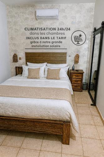 ein Schlafzimmer mit einem großen Bett mit weißen Laken und Kissen in der Unterkunft Villa Kaba Hippodrome Électricité solaire 24h24 in Bamako
