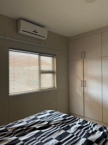 a bedroom with a bed and a window at MicasaKollections - Villa Ndahafa in Ongwediva