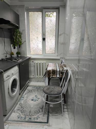 eine Küche mit einem Tisch und einer Waschmaschine in der Unterkunft Miledi in Bălţi