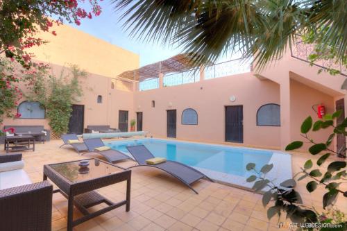 a courtyard with a swimming pool in a house at Guest House Bagdad Café in Aït Ben Haddou