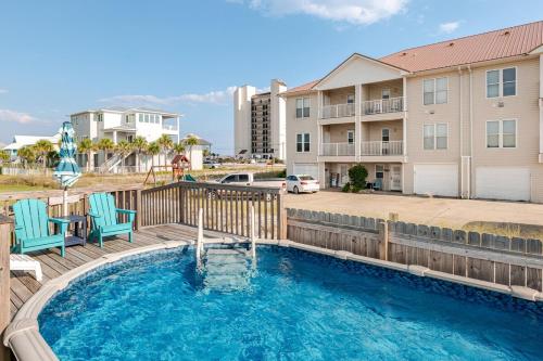 ein Pool mit zwei Stühlen und ein Gebäude in der Unterkunft Kokomo Key on Navarre Beach - Private Pool in Navarre