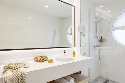 a white bathroom with a sink and a mirror at Sunwing Fañabe Beach in Adeje