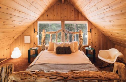 Pine CoveにあるThe Dusk House - An Idyllwild A-Frameの丸太小屋にある大きなベッドのある寝室