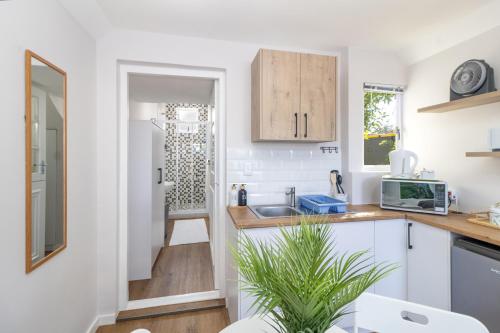 a kitchen with white cabinets and a sink at Hideaway Self-Catering Studio in Melkbosstrand