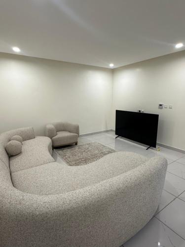a living room with a couch and a flat screen tv at Sea and lake view apartment in Muscat