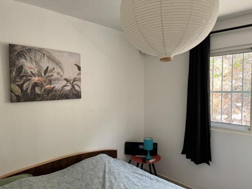 a bedroom with a bed and a large lamp at Le SPRITZ - Appartement d'une chambre VUE MER in Marigot