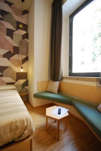 a room with a bed and a window and a table at Concoct Milano in Milan