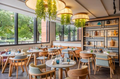 ein Restaurant mit Tischen und Stühlen und Fenstern in der Unterkunft FirstName Toulouse Résidence in Toulouse