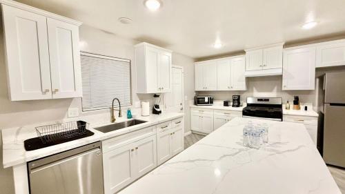 une cuisine avec des armoires blanches et un comptoir en marbre dans l'établissement LRG 1600sqft 4room 2 bath in a quiet neighborhood, à Bakersfield