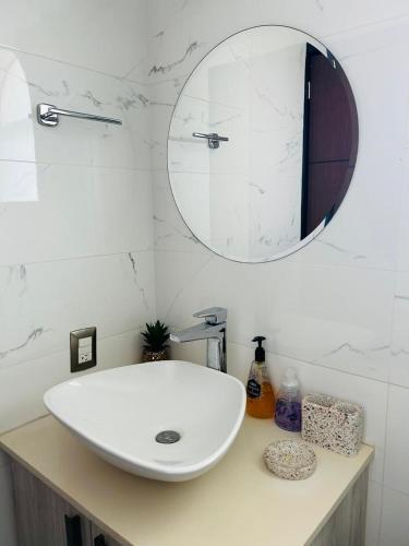 a bathroom with a white sink and a mirror at departamento frete al mar in Manzanillo
