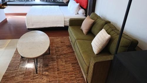 a living room with a couch and a table and a bed at Ruby Apartment #35 in Kejayan