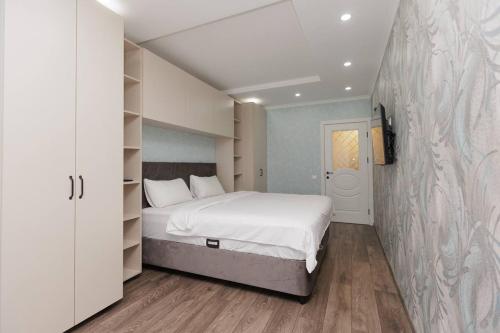 een slaapkamer met een wit bed en een muur bij Apartament Centru Chisinau in Chişinău