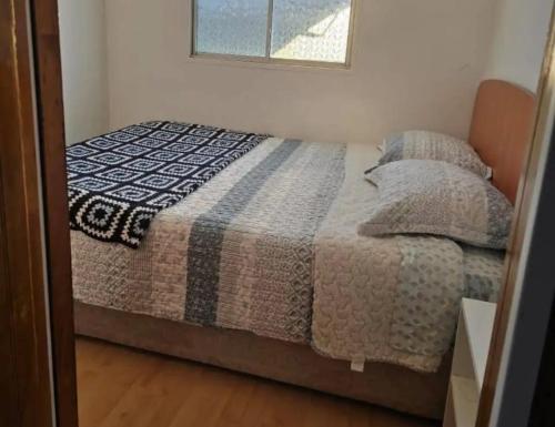 a bedroom with a bed with a quilt on it at Hospedaje violetta in Pichilemu
