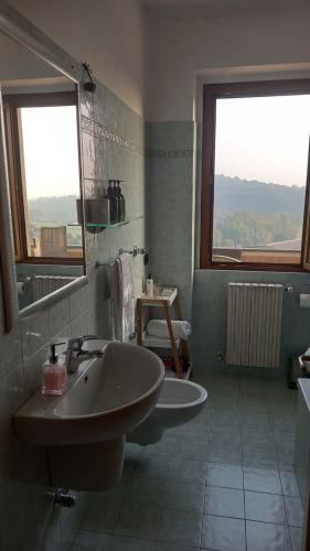 a bathroom with a sink and a mirror and window at B&B MiraValle in Scanzorosciate