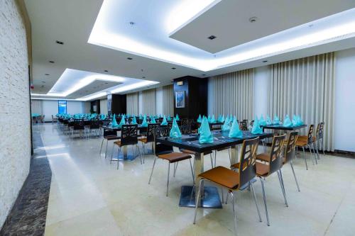 una sala conferenze con tavoli e sedie con tovaglioli blu sopra di فندق آراك الشريعة a Ajyad