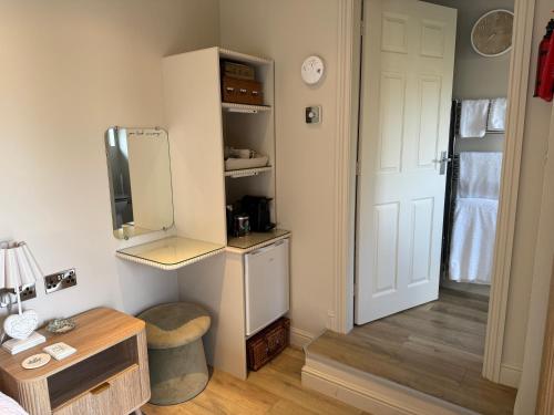 a room with a bed and a tv and a door at "The Lodge", Holmfirth in Holmfirth