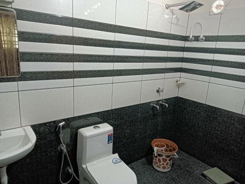 a bathroom with a toilet and a sink at Tranquil Haven - An Ayur Escape Retreat in Kāyankulam