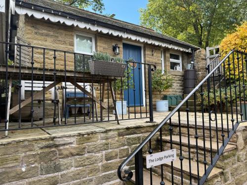 a stone house with a blue door and a staircase at "The Lodge", Holmfirth in Holmfirth