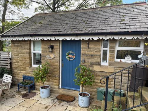 a small brick house with a blue door at "The Lodge", Holmfirth in Holmfirth