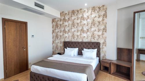 a bedroom with a bed and a wall at Metekhi Line By OldTown in Tbilisi City