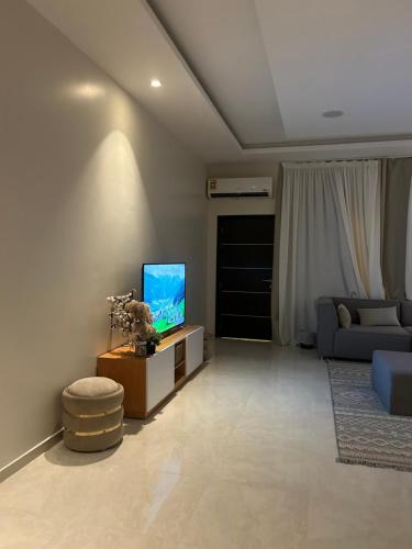 a living room with a couch and a television at Al Murjan Compound Villa in Jeddah