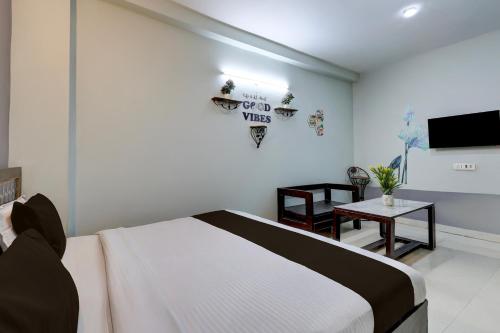 Un dormitorio con una cama, una mesa y un televisor. en Hotel O Dadri Main Road Greater Noida, en Greater Noida