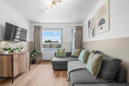 a living room with a couch and a tv at Modern Kensington Apartments in London