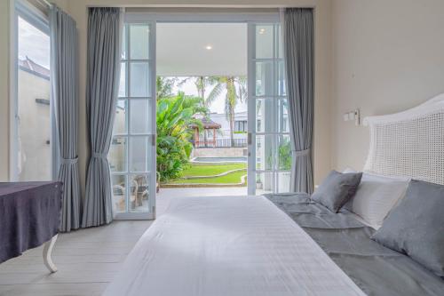 Un dormitorio con una cama y una gran puerta corrediza de vidrio. en The Beautiful villa, Casa Sara, en Canggu