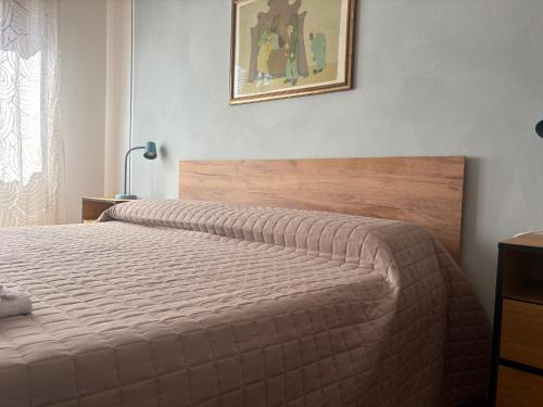a bedroom with a bed and a picture on the wall at Home Sweet Home Affittacamere - Lucca in Lucca