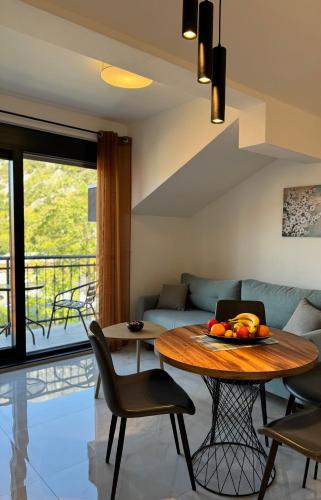 a living room with a table and a couch at Harmony Garden Apartments in Kotor