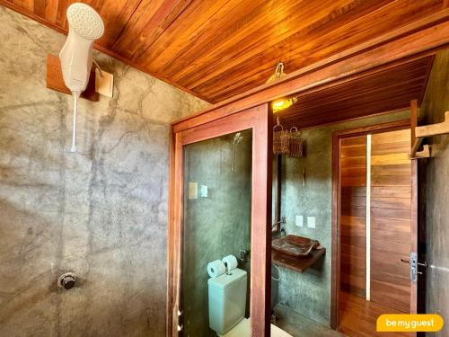 a bathroom with a shower and a toilet in it at Vila Pukara - Moitas in Praia de Moitas