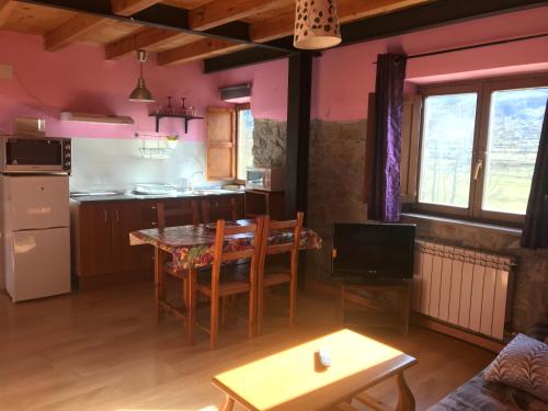 Una cocina y una sala de estar con mesa y sillas. en Apartamentos Besande, en Besande