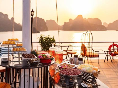 een buffet met eten op een balkon met uitzicht op het water bij Aurora Cruises in Ha Long