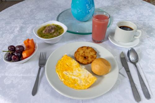 a table with a plate of breakfast food and a drink at Hotel Playa Salguero By GEH Suites in Santa Marta