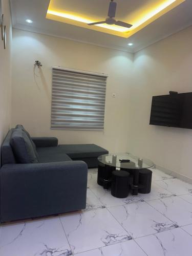 a living room with a couch and a table at Cozy 4 bedroom at community 18 near spintex in Spintex