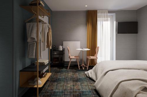 een slaapkamer met een bed, een tafel en stoelen bij Hôtel Kempf in Colmar