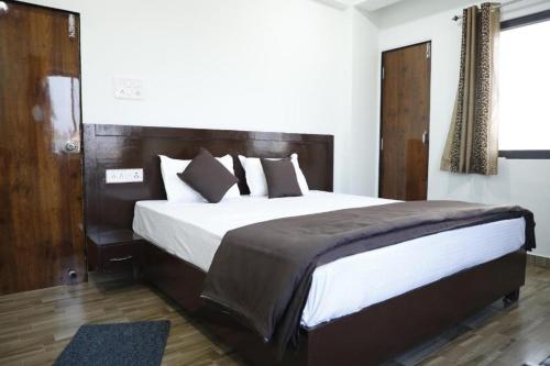 a bedroom with a large bed with a wooden headboard at Shree mahal in Jāmb