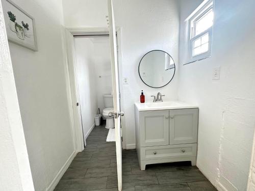 a white bathroom with a sink and a mirror at Speciose Unit With Kitchen And Community Pool in Clearwater